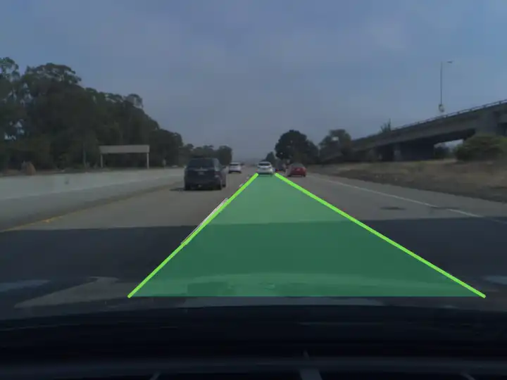 A dashcam view of a freeway: the lane ahead of the car is filled in translucent green between two green lines that follow its markings up to the horizon