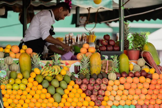 A market fruit stall with several hundred detected corners marked, clustered on the fruit boundaries and the stall structure