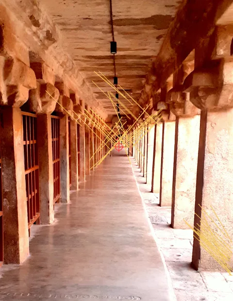 A temple cloister with 60 detected lines drawn over it, all converging on a marked point at the end of the corridor