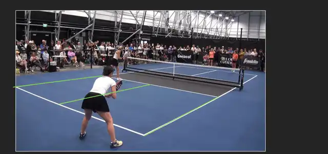 A pickleball court photographed from behind one corner; the two sidelines and the centre line are extended past the edge of the frame until they meet at one point to the right of the image
