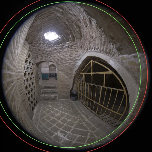 A circular fisheye photograph with two circles drawn on it: the larger predicted radius and the smaller measured one